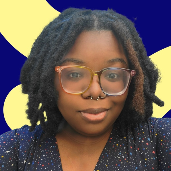 A woman with glasses and a septum nose ring, her hair styled in dreadlocks, smiles gently against a yellow and blue geometric background.