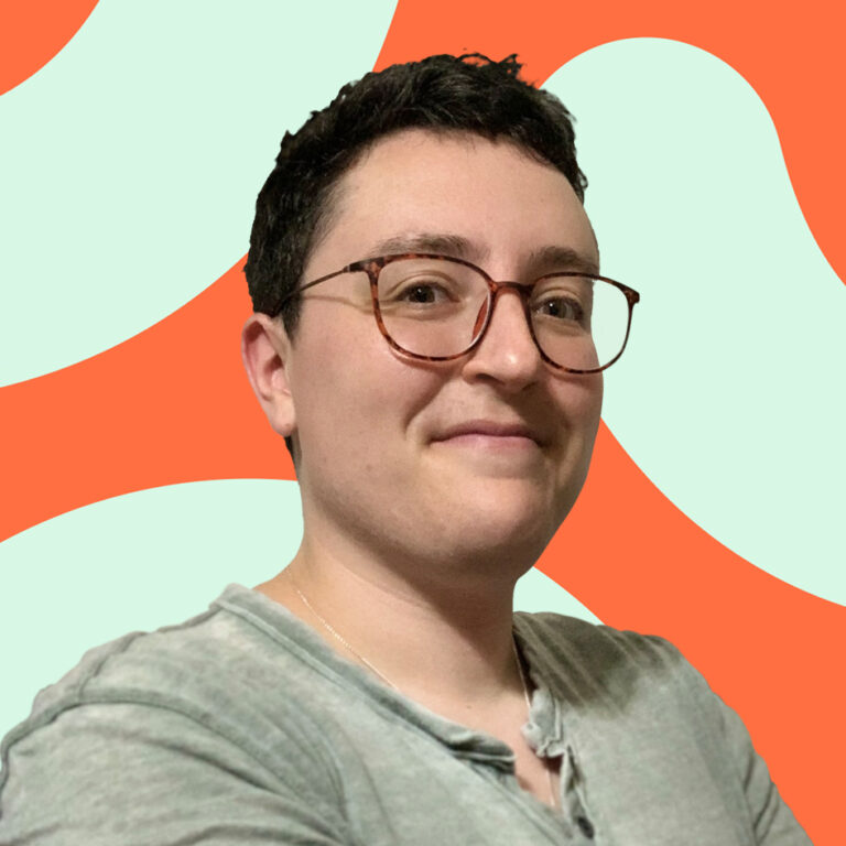A person with short dark hair and round glasses smiles slightly, wearing a gray top. the background features abstract orange and teal shapes.