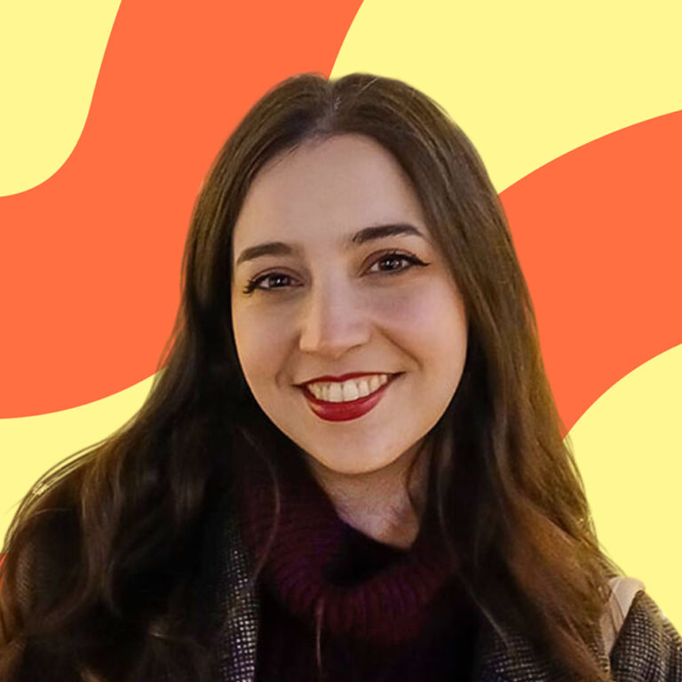 Woman with long brown hair smiling in front of a yellow and orange wavy background.