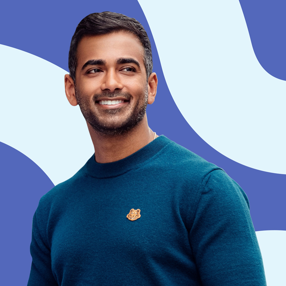 Man with short dark hair and beard in a teal sweater, smiling in front of a blue and white abstract background.